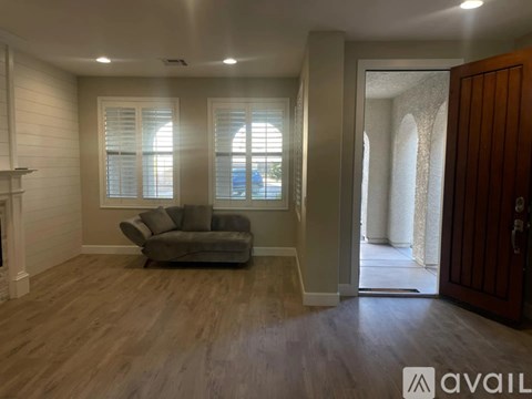 A living room with a grey couch and wooden floors.