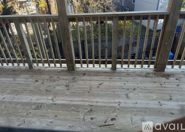 A wooden deck with a railing and some debris on it.