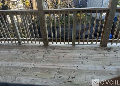 A wooden deck with a railing and some debris on it.