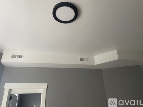 A white ceiling with a black ring and two vents.