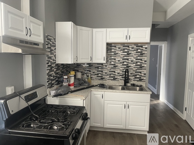 A kitchen with a black stove top oven and white cabinets.