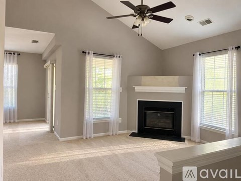 A living room with a fireplace and a ceiling fan.
