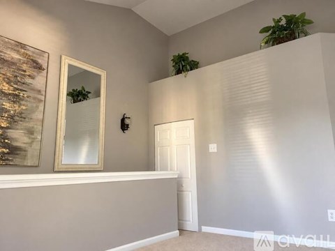 A room with a white door and a mirror on the wall.