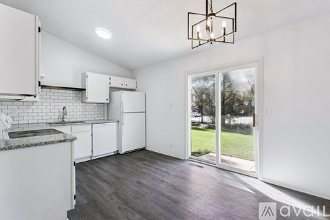 A kitchen with white cabinets and a grey countertop.