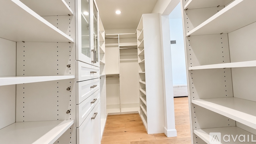 A white walk-in closet with shelves and drawers.