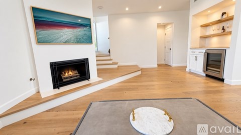 A modern living room with a fireplace and a painting on the wall.