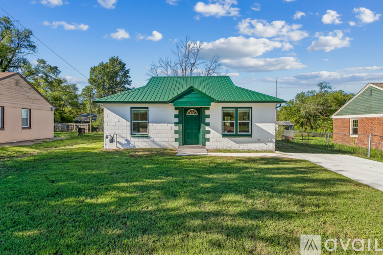A house with a green roof is for sale.