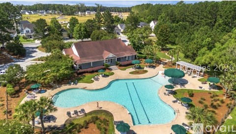 A bird's eye view of a resort with a swimming pool and a house.