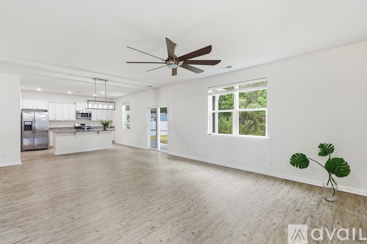 A spacious room with a ceiling fan and a large window.