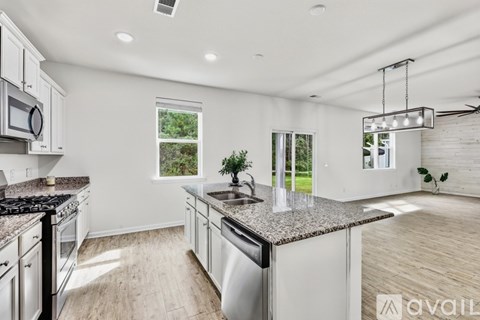 A modern kitchen with granite countertops and stainless steel appliances.
