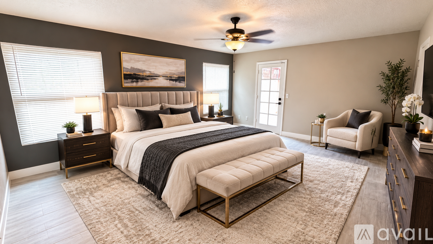 A bedroom with a large bed, a chair, and a ceiling fan.