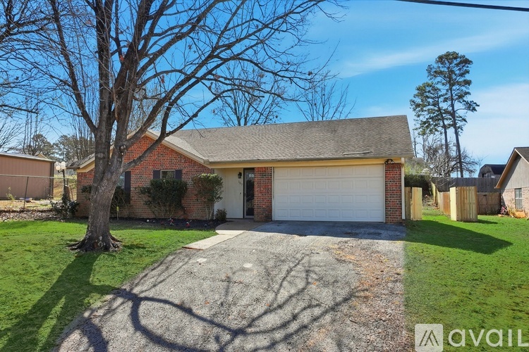 A house with a garage and a tree in front.
