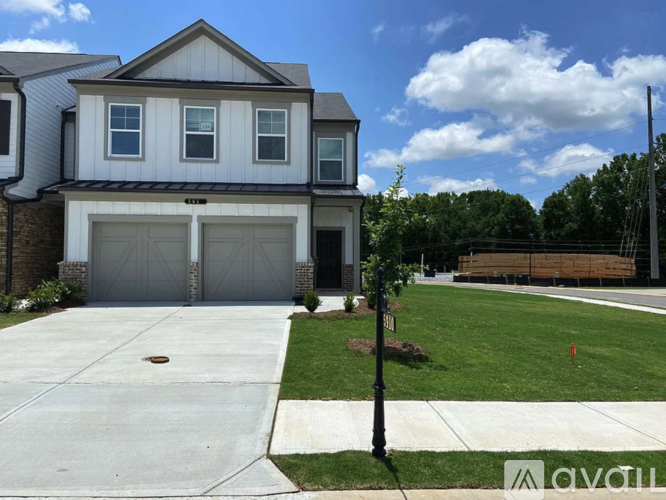 A two-story house with a garage and a driveway.