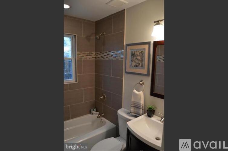 A bathroom with a tub, sink, and mirror.