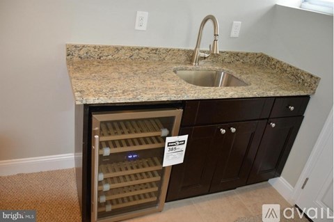 A kitchen counter with a sink and a wine rack.