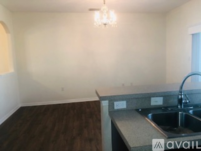 A kitchen with a sink and a chandelier.