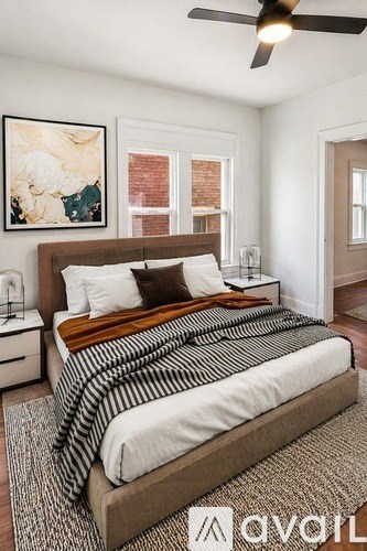 A bedroom with a large bed and a ceiling fan.