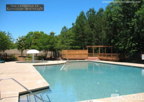 A pool with a deck and a sun umbrella is available for rent.