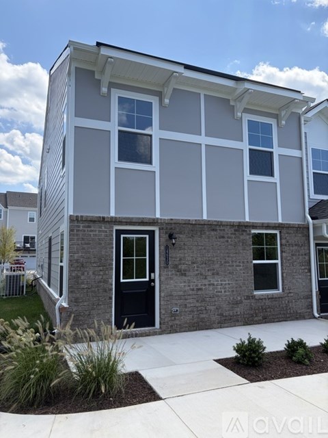 A modern two-story house with a black front door and white trim.