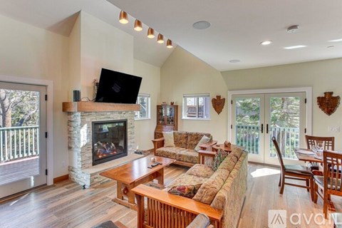 A living room with a fireplace and a television on the wall.
