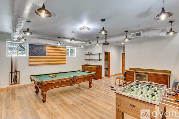 A room with a pool table and a foosball table.