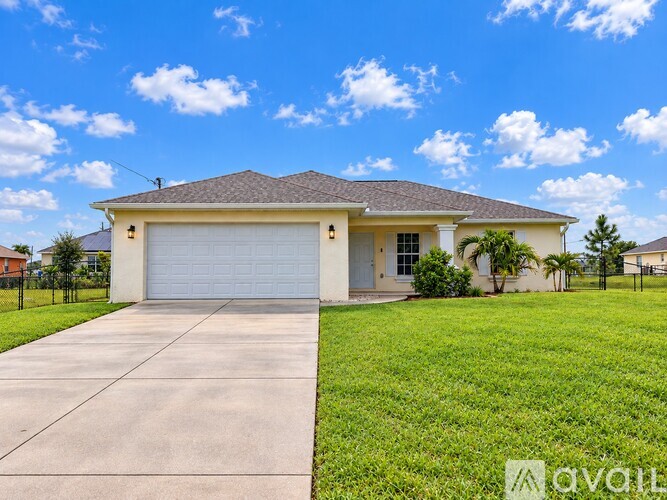 A house with a garage and a driveway in front of it.