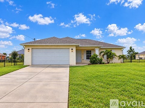 A house with a garage and a driveway in front of it.