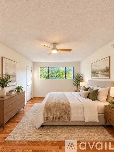 A bedroom with a bed, a dresser, and a ceiling fan.