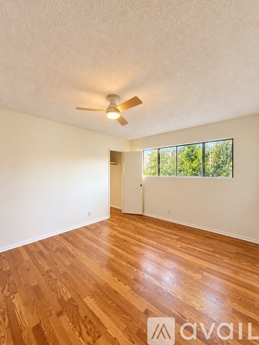 A room with wooden flooring and a ceiling fan.