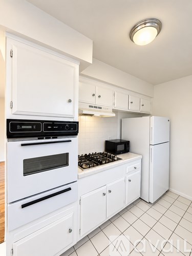 A kitchen with white appliances and cabinets.