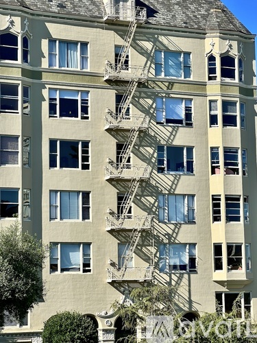 A tall building with a fire escape on the side.