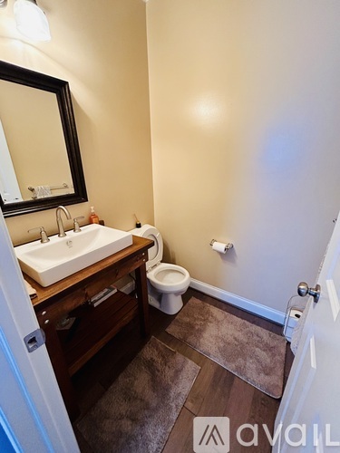 A bathroom with a sink, toilet, and mirror.