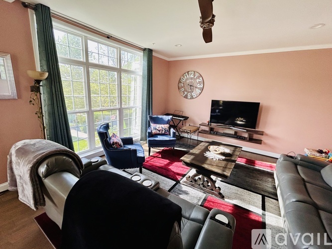 A living room with a couch, chair, and television.