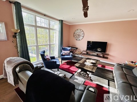 A living room with a couch, chair, and television.
