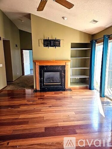 A living room with a fireplace and wood flooring.