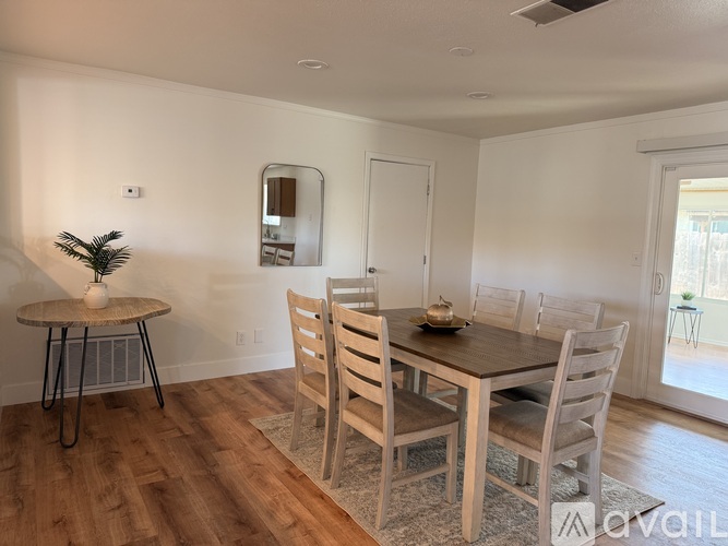 A dining room with a wooden table and chairs.