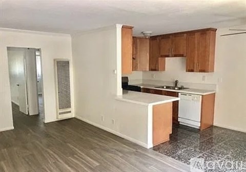 A kitchen with wooden cabinets and a white island.