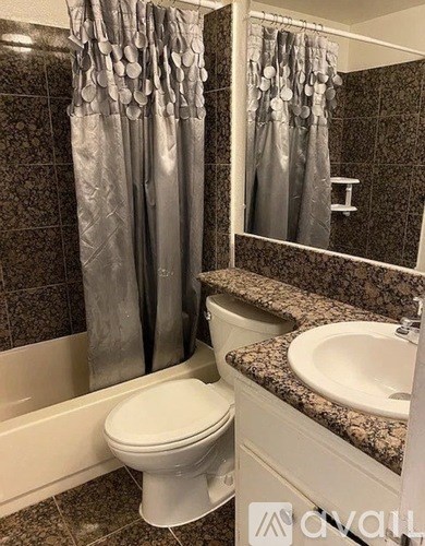 A white toilet sits next to a sink in a bathroom.