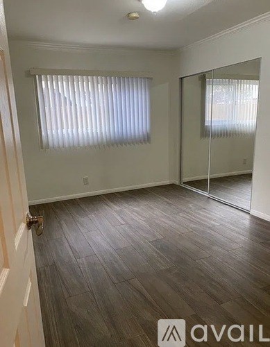 A room with wooden flooring and a sliding glass door.
