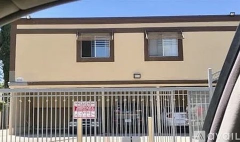 A building with a sign on a gate in front of it.