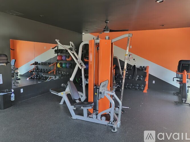 A gym with orange walls and a variety of equipment.