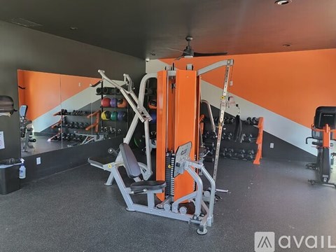 A gym with orange walls and a variety of equipment.