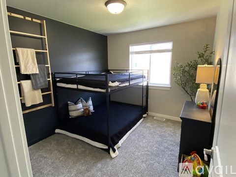 A bedroom with a bunk bed and a window.