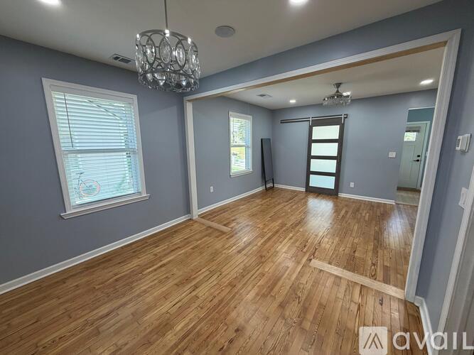 A room with wooden flooring and a chandelier.