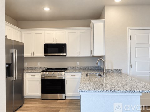A kitchen with white cabinets and a granite countertop.