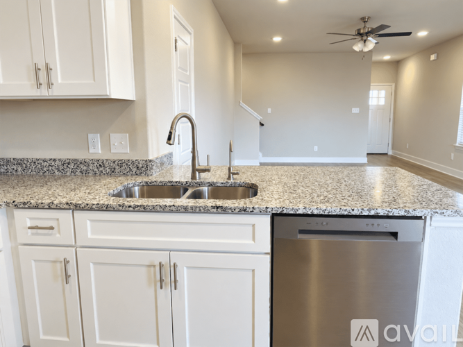 A kitchen with white cabinets and a granite countertop.