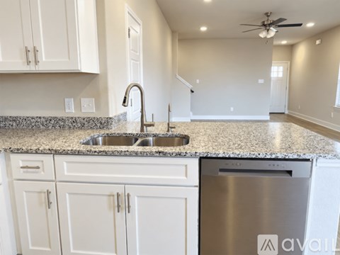 A kitchen with white cabinets and a granite countertop.