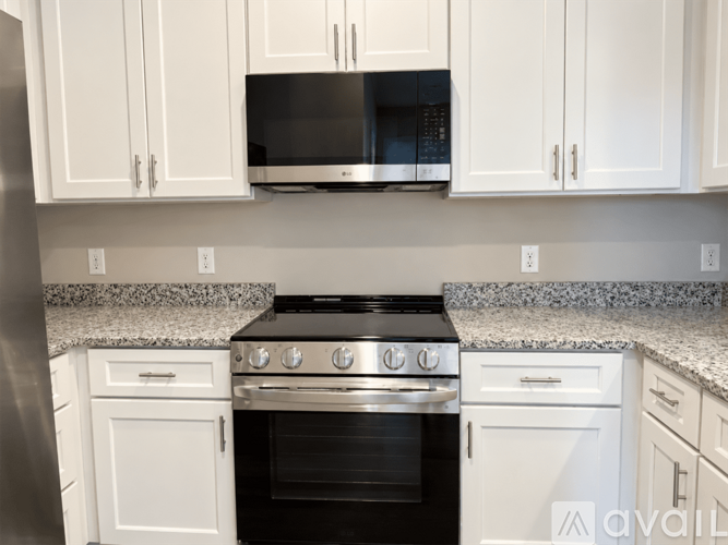 A kitchen with white cabinets and a black stove top oven.