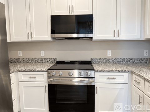 A kitchen with white cabinets and a black stove top oven.