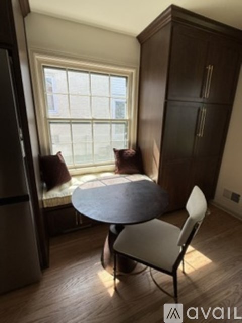 A kitchen with a table and chairs by a window.